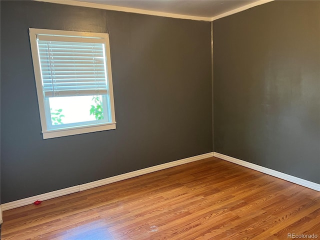 spare room with crown molding and hardwood / wood-style flooring