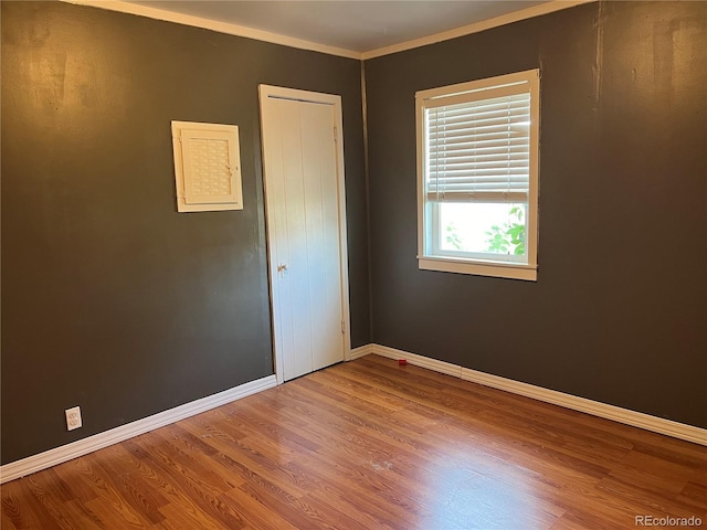 empty room featuring ornamental molding and wood-type flooring