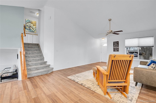 living room featuring light wood finished floors, stairs, high vaulted ceiling, and a ceiling fan