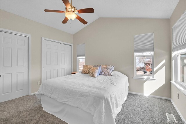 carpeted bedroom featuring a ceiling fan, lofted ceiling, visible vents, and baseboards