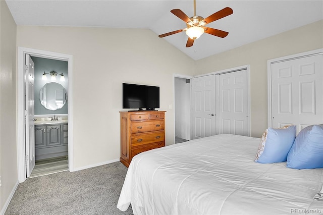 carpeted bedroom featuring lofted ceiling, ceiling fan, connected bathroom, baseboards, and a closet