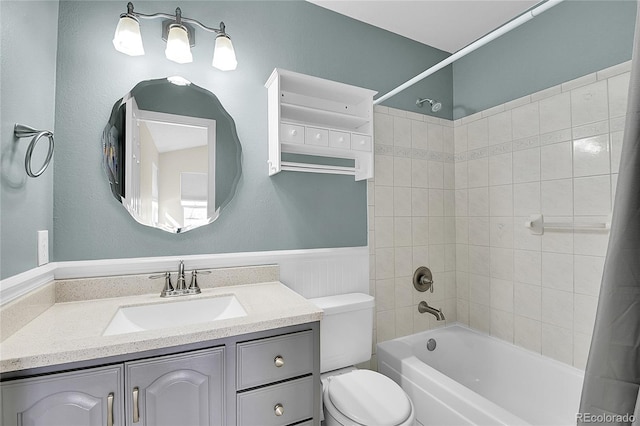 bathroom featuring shower / tub combo, wainscoting, vanity, and toilet