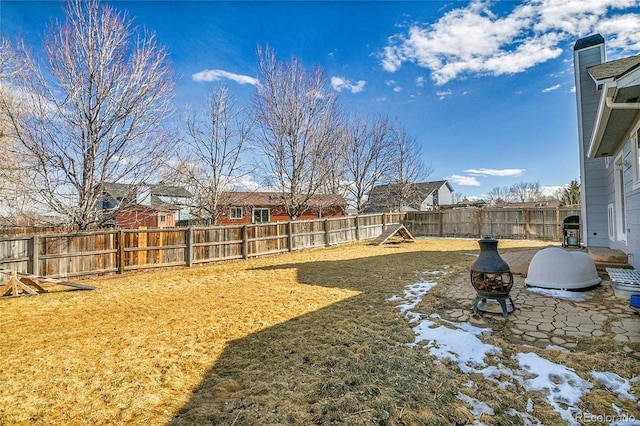 view of yard with a fenced backyard, a fire pit, and a patio