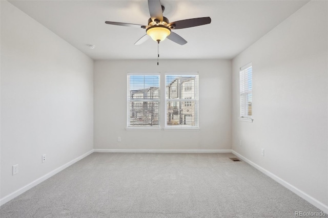 carpeted empty room featuring ceiling fan and a wealth of natural light