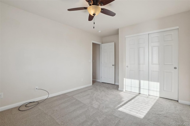 unfurnished bedroom featuring ceiling fan, a closet, and light colored carpet