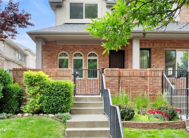 538 Cook St, Denver, CO 80206 - entrance to property featuring brick siding, roof with shingles, and covered porch