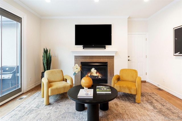 538 Cook St, Denver, CO 80206 - sitting room with wood finished floors, a tiled fireplace, crown molding, and recessed lighting