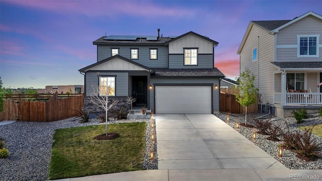 21 N Edge Cliff St, Castle Rock, CO 80104 - view of front facade featuring board and batten siding, fence, roof mounted solar panels, and an attached garage