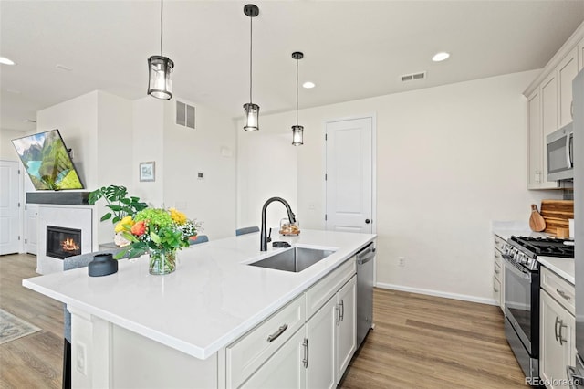 21 N Edge Cliff St, Castle Rock, CO 80104 - kitchen with a sink, stainless steel appliances, light wood-style flooring, recessed lighting, and light countertops