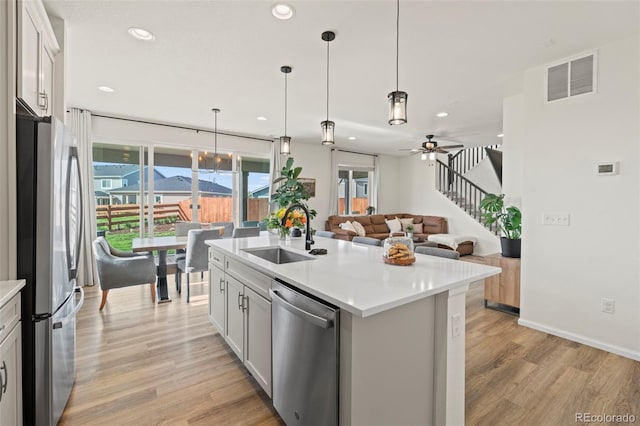21 N Edge Cliff St, Castle Rock, CO 80104 - kitchen with appliances with stainless steel finishes, a sink, light wood-type flooring, a ceiling fan, and light countertops
