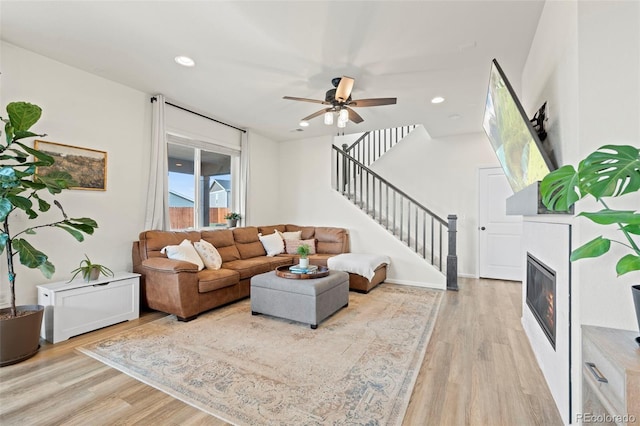 21 N Edge Cliff St, Castle Rock, CO 80104 - living area with light wood-style floors, stairway, ceiling fan, a glass covered fireplace, and recessed lighting