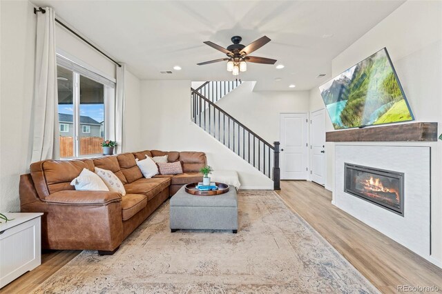 21 N Edge Cliff St, Castle Rock, CO 80104 - living room with wood finished floors, stairs, a ceiling fan, a glass covered fireplace, and recessed lighting