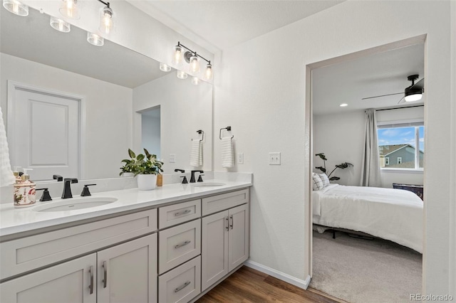 21 N Edge Cliff St, Castle Rock, CO 80104 - ensuite bathroom featuring double vanity, wood finished floors, baseboards, and ceiling fan
