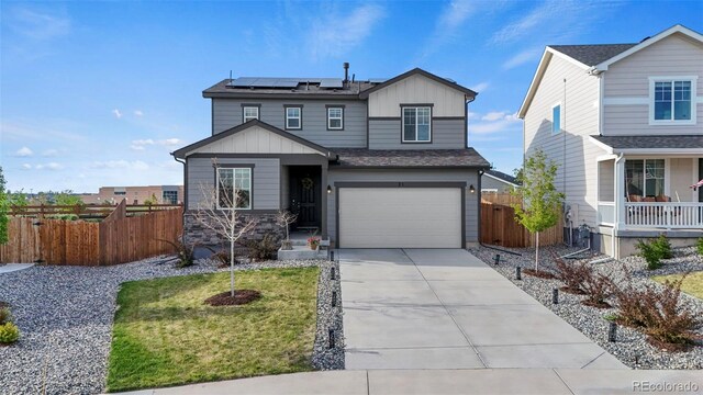 21 N Edge Cliff St, Castle Rock, CO 80104 - view of front facade with board and batten siding, roof mounted solar panels, concrete driveway, an attached garage, and covered porch