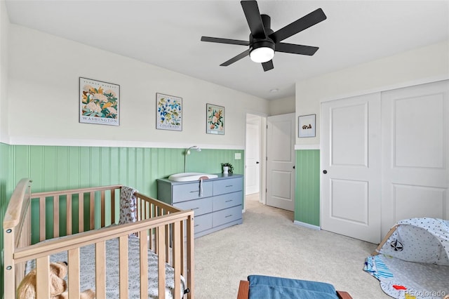 21 N Edge Cliff St, Castle Rock, CO 80104 - bedroom featuring carpet floors, a wainscoted wall, a closet, a ceiling fan, and a nursery area