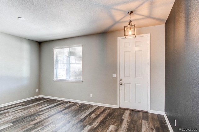 entrance foyer featuring dark wood-type flooring and a textured ceiling