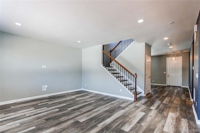 unfurnished room featuring dark hardwood / wood-style flooring and a textured ceiling