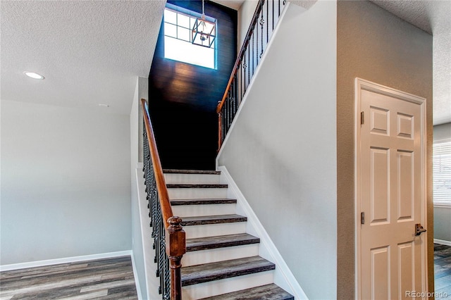 stairway featuring hardwood / wood-style flooring and a textured ceiling