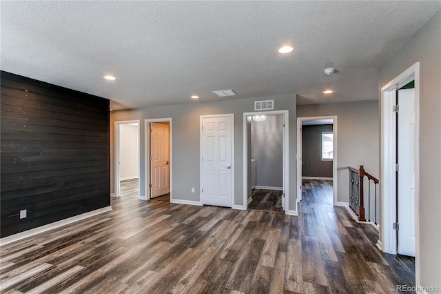 empty room featuring dark wood-type flooring and a textured ceiling