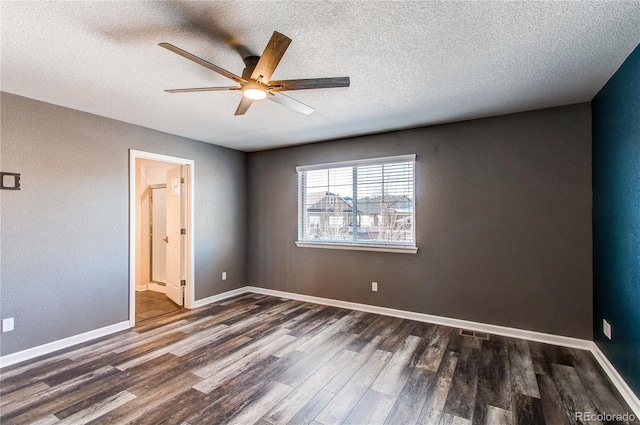 empty room with a textured ceiling, dark wood-type flooring, and ceiling fan