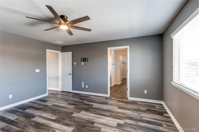 unfurnished bedroom with ceiling fan, dark hardwood / wood-style floors, and a textured ceiling