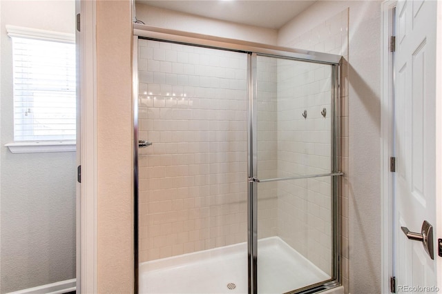 bathroom featuring a shower with shower door