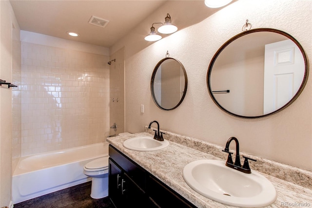 full bathroom featuring vanity, hardwood / wood-style flooring, toilet, and tiled shower / bath