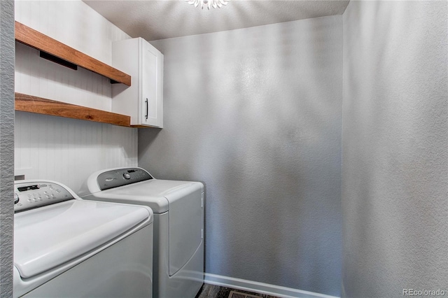 laundry area featuring separate washer and dryer and cabinets