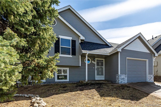 split level home with concrete driveway, a garage, and roof with shingles