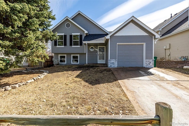 tri-level home featuring concrete driveway and a garage