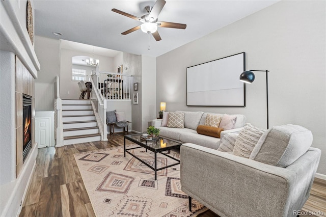 living room featuring wood-type flooring and ceiling fan with notable chandelier