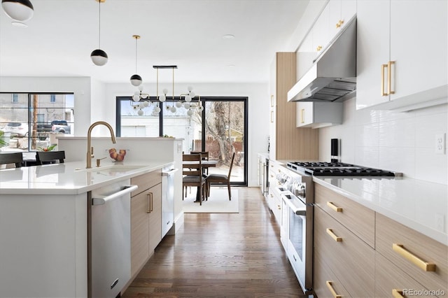 kitchen with sink, plenty of natural light, stainless steel appliances, and hanging light fixtures