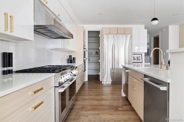 kitchen with hanging light fixtures, appliances with stainless steel finishes, sink, and white cabinets