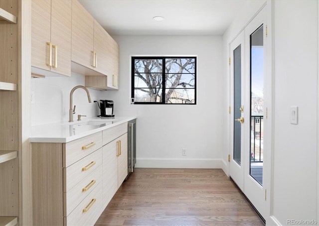 kitchen featuring sink, a wealth of natural light, light brown cabinetry, and light wood-type flooring