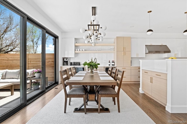 dining room with an inviting chandelier and light hardwood / wood-style flooring