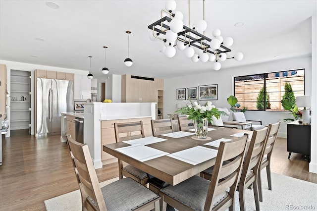 dining area featuring wood-type flooring and a chandelier