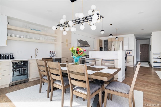 dining room with wine cooler, indoor wet bar, and hardwood / wood-style flooring