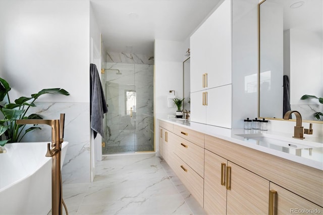full bathroom with double vanity, marble finish floor, a freestanding tub, a sink, and a marble finish shower