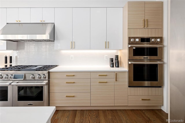 kitchen with light countertops, stainless steel appliances, extractor fan, and backsplash