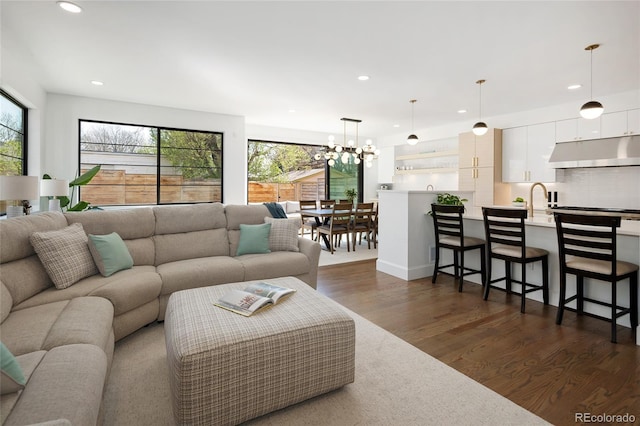 living room with recessed lighting, dark wood finished floors, and plenty of natural light