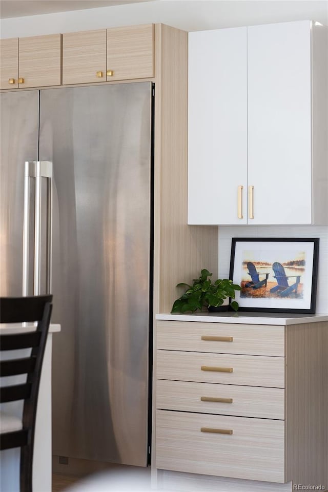 kitchen featuring freestanding refrigerator, modern cabinets, and light countertops