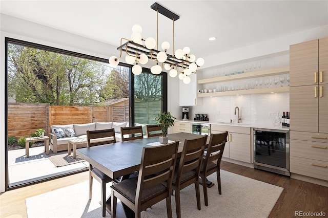 dining space featuring recessed lighting, wet bar, dark wood-style flooring, and beverage cooler