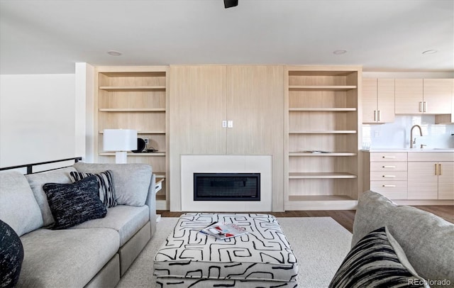living area with a tiled fireplace and wood finished floors