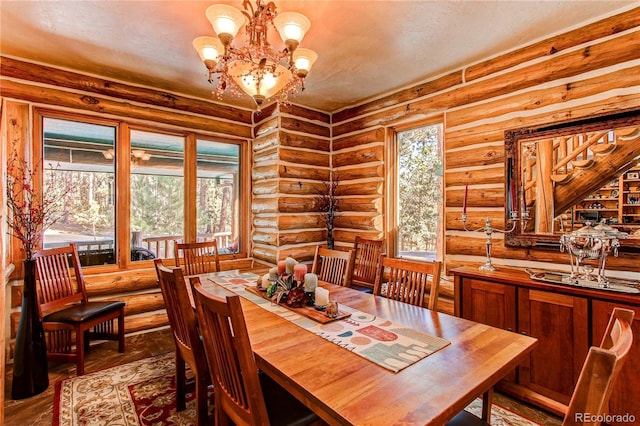 dining space featuring log walls, a chandelier, and wood-type flooring