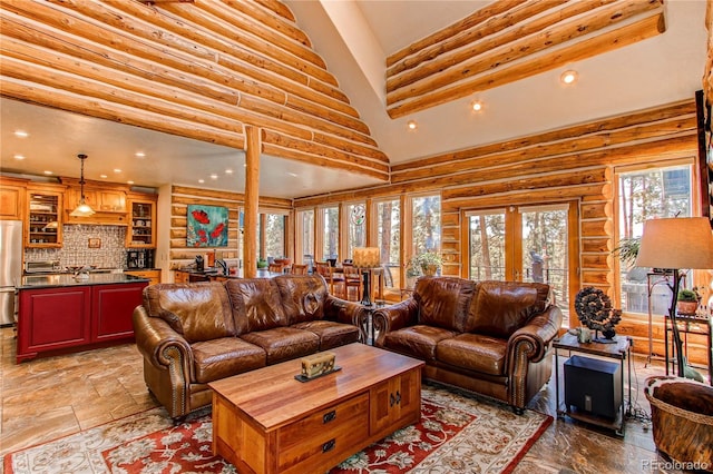 living room with log walls and high vaulted ceiling