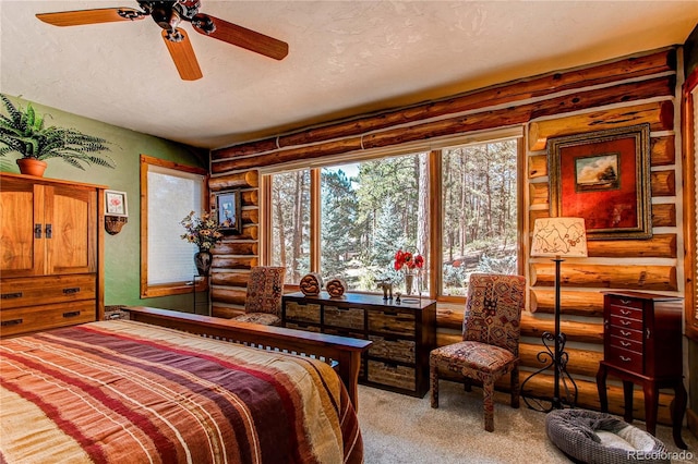 bedroom featuring a textured ceiling, rustic walls, and ceiling fan