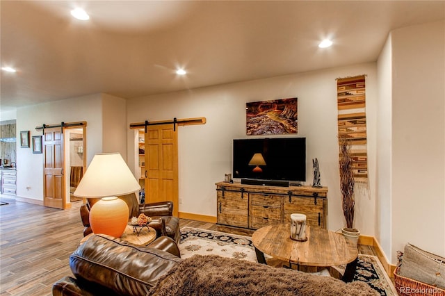 living room with a barn door and light hardwood / wood-style floors