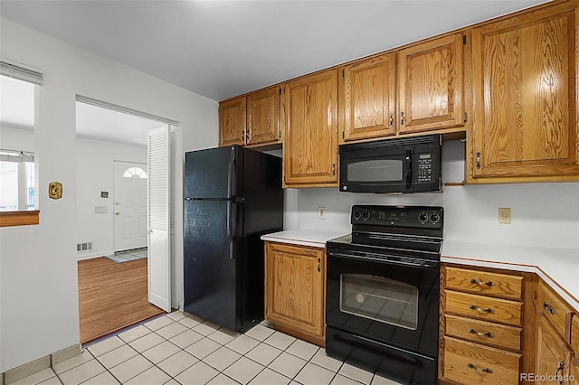 920 Emerson Cir, Northglenn, CO 80233 - kitchen with black appliances, light countertops, and brown cabinets
