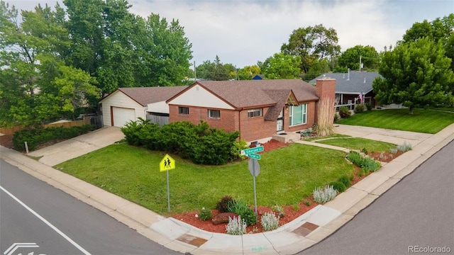 920 Emerson Cir, Northglenn, CO 80233 - view of front of house with brick siding, driveway, a front yard, and an outdoor structure