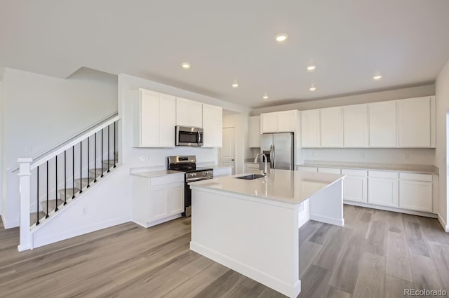 kitchen featuring white cabinetry, sink, an island with sink, and stainless steel appliances